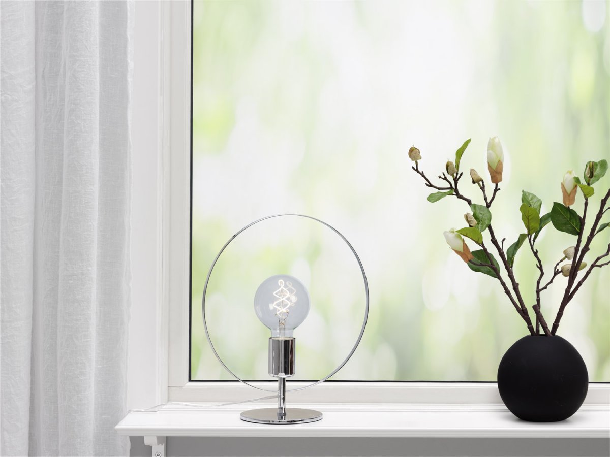 Spartan ringo 35cm Chrom bordlampe Fra Cottex - Spartansk Ringo bordlampe i metal er en moderne og minimalistisk lampe, der trækker øjet med sit elegante cirkulære design.