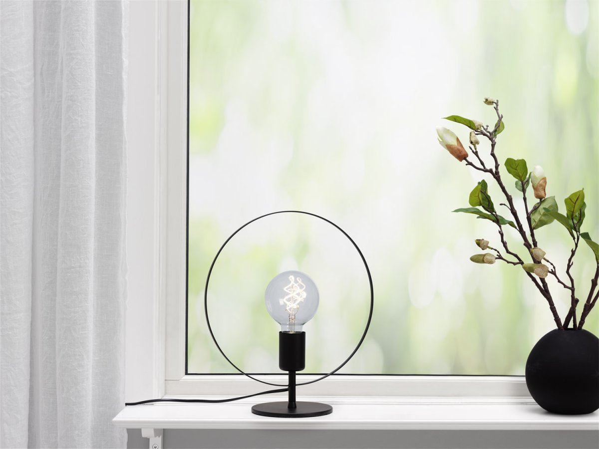 Spartan ringo 35cm Sort bordlampe Fra Cottex - Spartansk Ringo bordlampe i metal er en moderne og minimalistisk lampe, der trækker øjet med sit elegante cirkulære design.