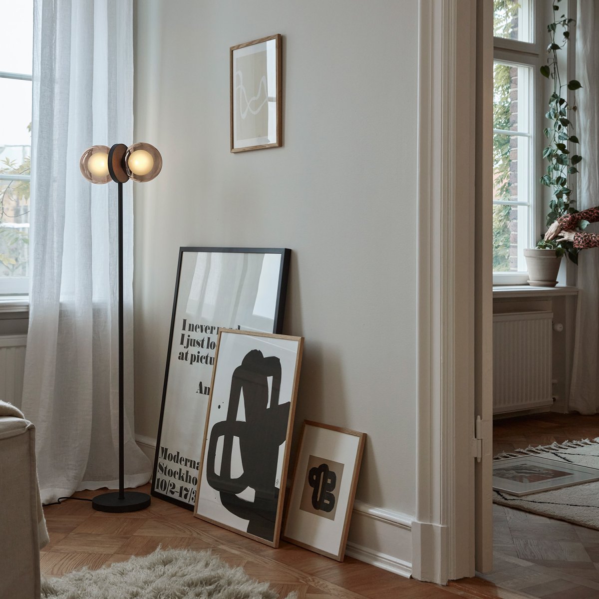 Discus Sort gulvlampe Fra CO Bankeryd - De opalglaskupler er indkapslet i røget glas, der giver et varmt dekorativt lys i rummet.