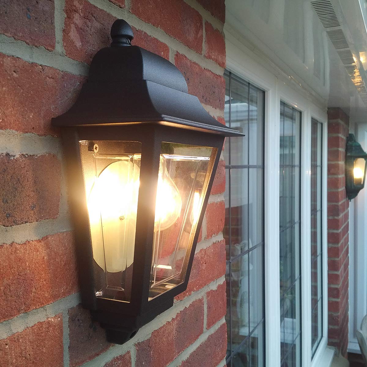 Deco Lane 32cm Sort udendørslampe Fra Elstead Lighting - Den er lavet af sortlakeret aluminium og polycarbonat og tilbyder en let, men robust konstruktion, der er holdbar og langtidsholdbar.