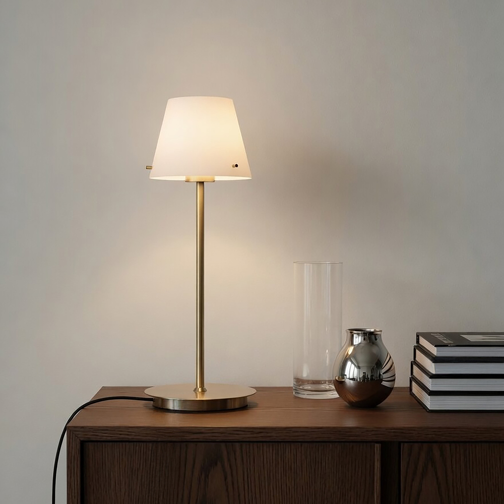 Gil 34cm Satin messing bordlampe Fra Herstal - Den er lavet af metal med en satineret messingfinish og har en hvid glassk&aelig;rm, der spreder et bl&oslash;dt og behageligt lys.