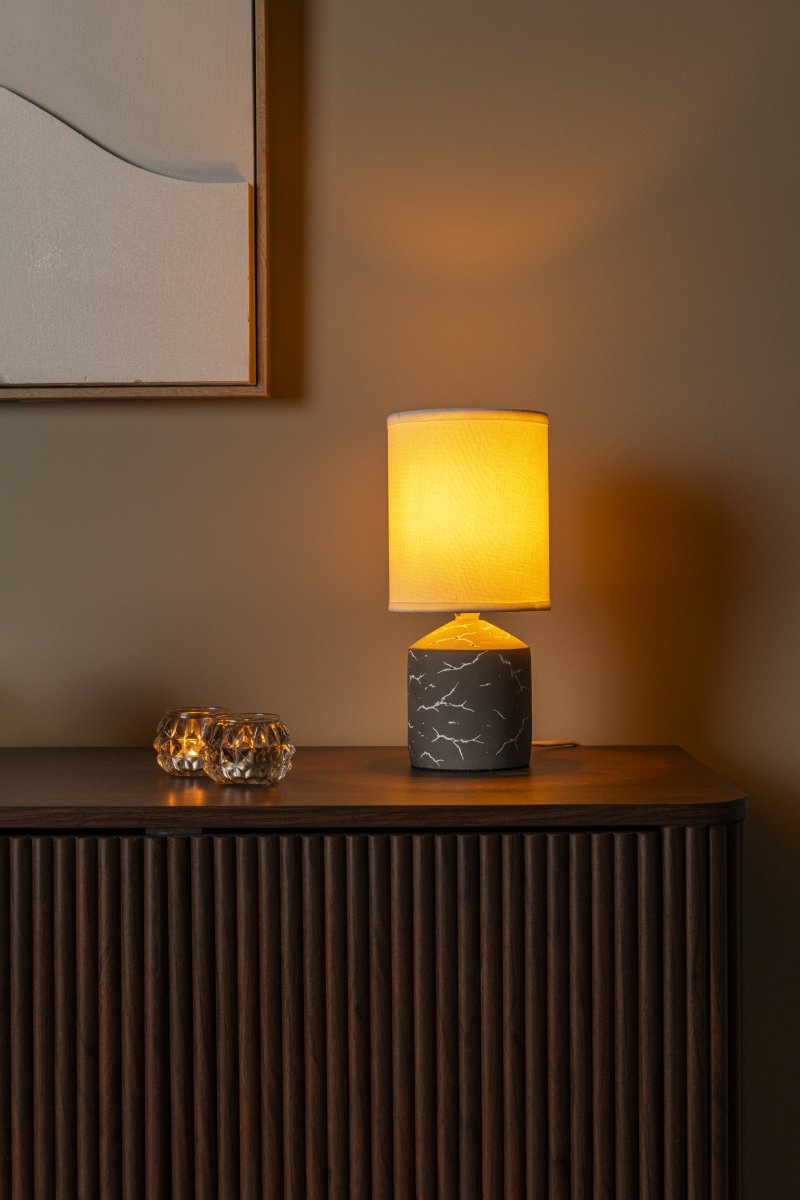 Fran 30cm Taupe bordlampe Fra Lucide - Det hvide, uregelmæssige mørke mønster på foden giver et marmoreret udseende og skaber en flot kontrast mod den mørke overflade.