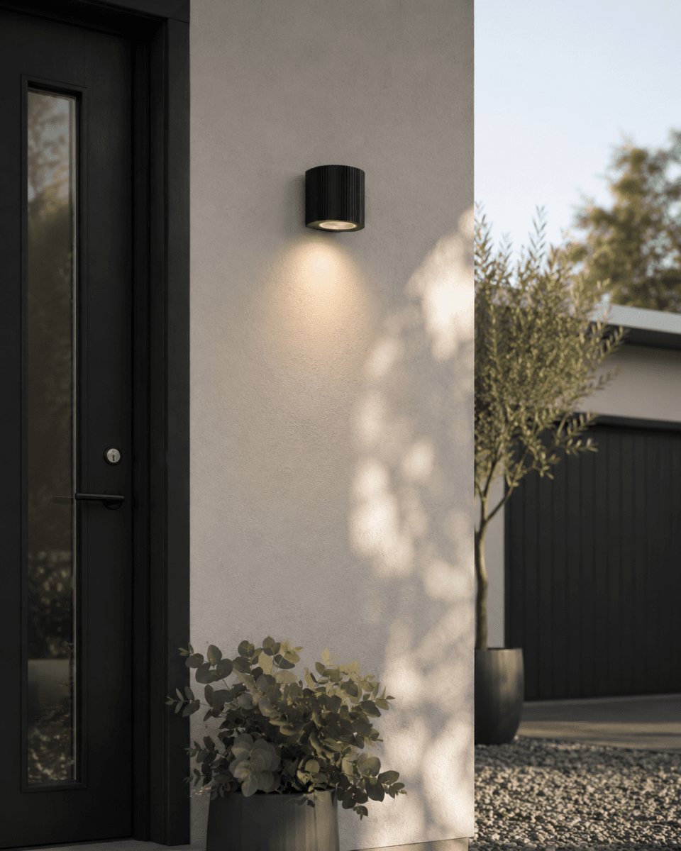 Freja Single Sort udendørslampe Fra Lampan - Lavet af sortlakeret metal med en dekorativ ribbet struktur, der giver lampen et livligt og eksklusivt udseende.