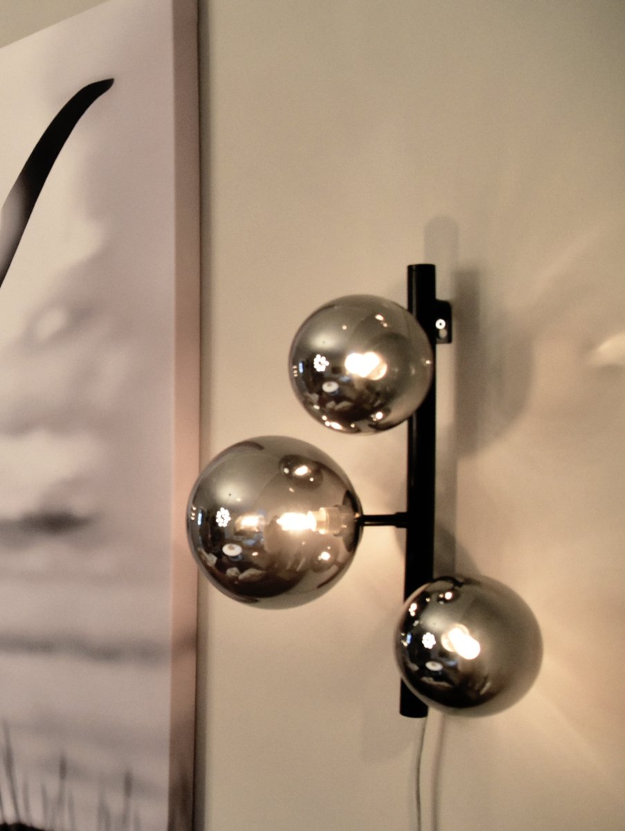 Molekyl 36cm Røg grå væglampe Fra Aneta Lighting - Den er lavet af sort metal og har skærme i røget glas, der spreder et blødt og behageligt lys.