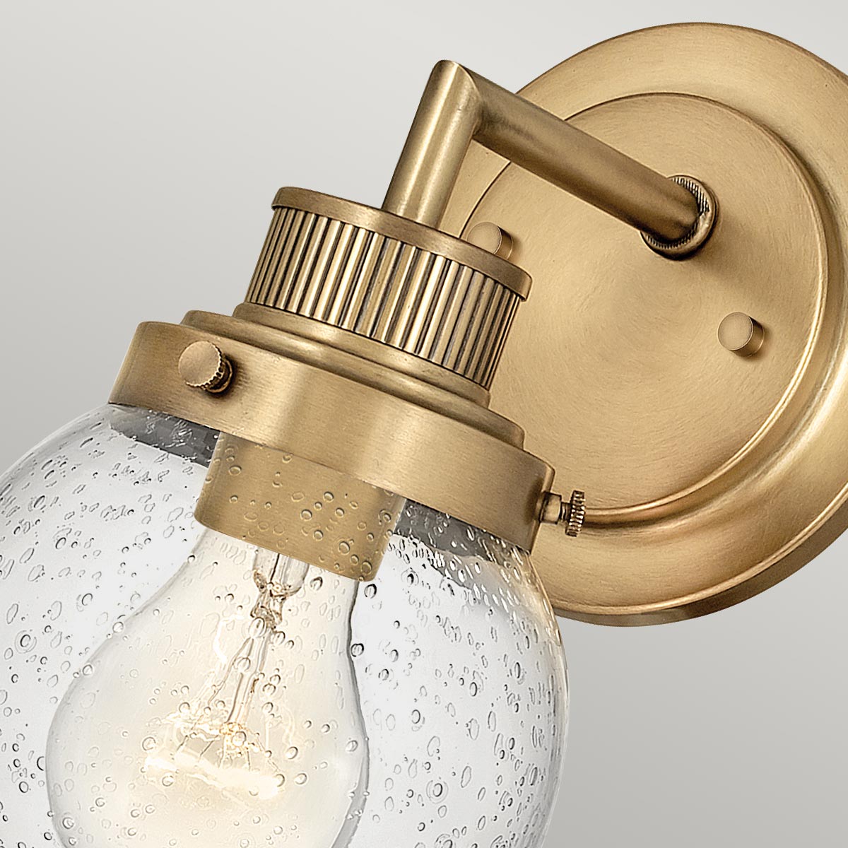 Poppy Ø13 Antik messing badeværelseslampe Fra Elstead Lighting - Den elegante og trappede bagplade og den rene tværstang giver stabilitet til det luftige design.