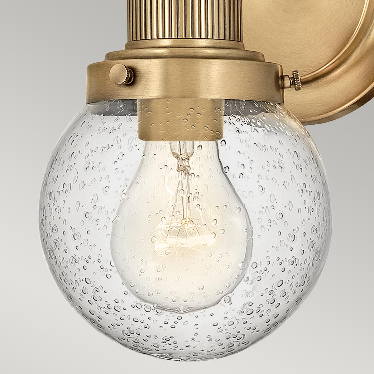 Poppy Ø13 Antik messing badeværelseslampe Fra Elstead Lighting - Den elegante og trappede bagplade og den rene tværstang giver stabilitet til det luftige design.