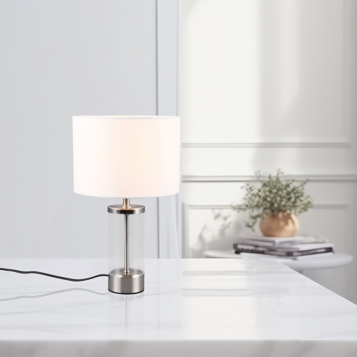 Grazia 34cm Hvid bordlampe Fra Trio Lighting - Bordlampen Grazia kombinerer en elegant stofskærm med en stilren cylindrisk fod i glas og metal, som giver et harmonisk og sofistikeret indtryk.