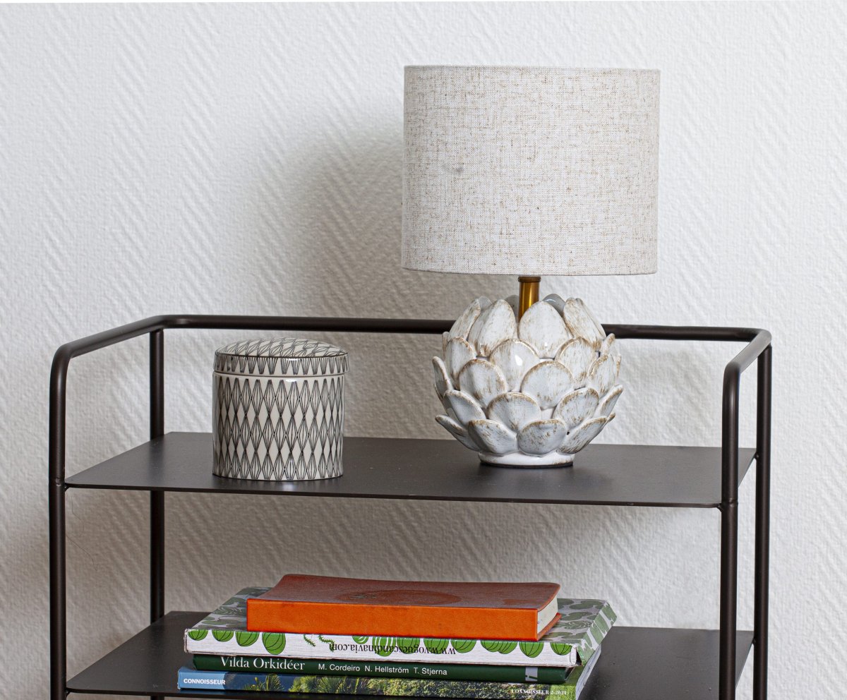 Rosanna 30cm Beige bordlampe Fra Cottex - Den keramiske lampefod i en rustik hvid farve kombineret med den beige hørskærm bidrager til en harmonisk atmosfære i rummet.