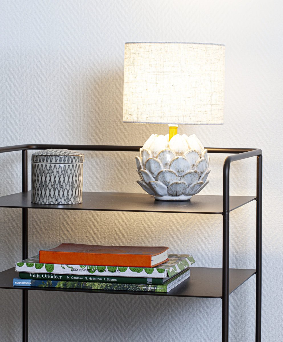 Rosanna 30cm Beige bordlampe Fra Cottex - Den keramiske lampefod i en rustik hvid farve kombineret med den beige hørskærm bidrager til en harmonisk atmosfære i rummet.