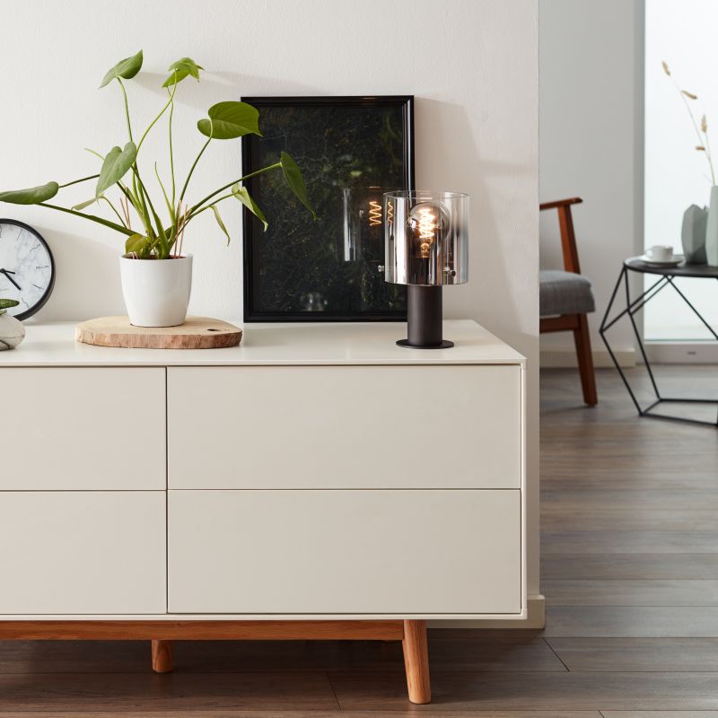 Beth 26cm Røgfarvet bordlampe Fra Brilliant - Den fungerer lige så godt som en dekorativ detalje, der giver lys til mørke hjørner og bidrager til en behagelig atmosfære i hjemmet.