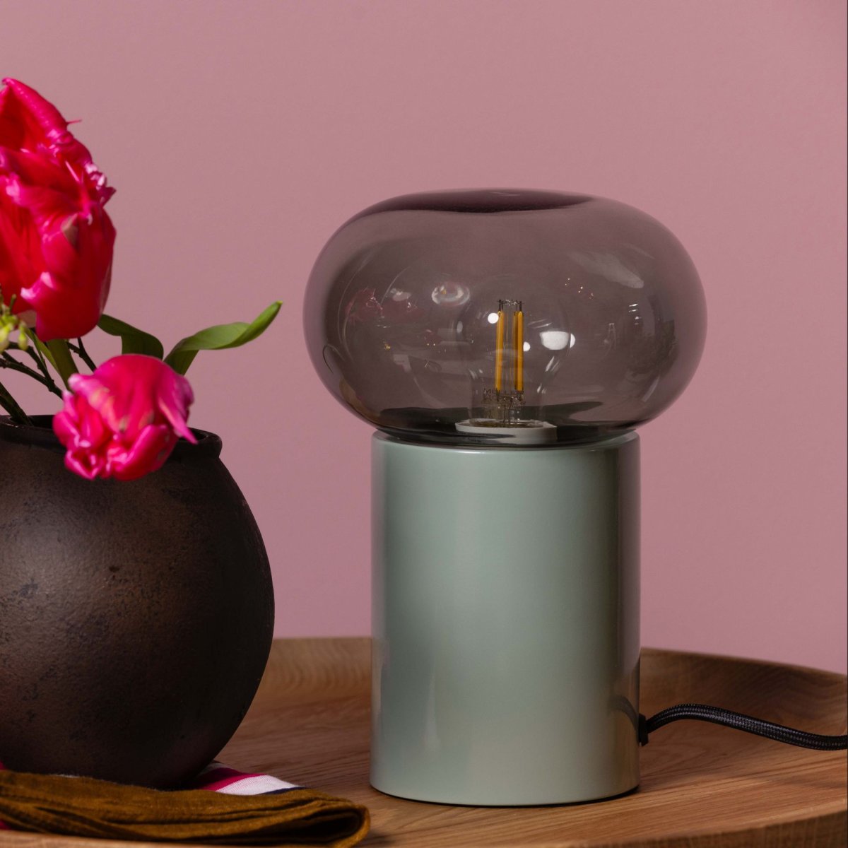 Knut 22cm Grøn bordlampe Fra Brilliant - Denne stilfulde bordlampe kombinerer metal og glas i et moderne og dekorativt design.