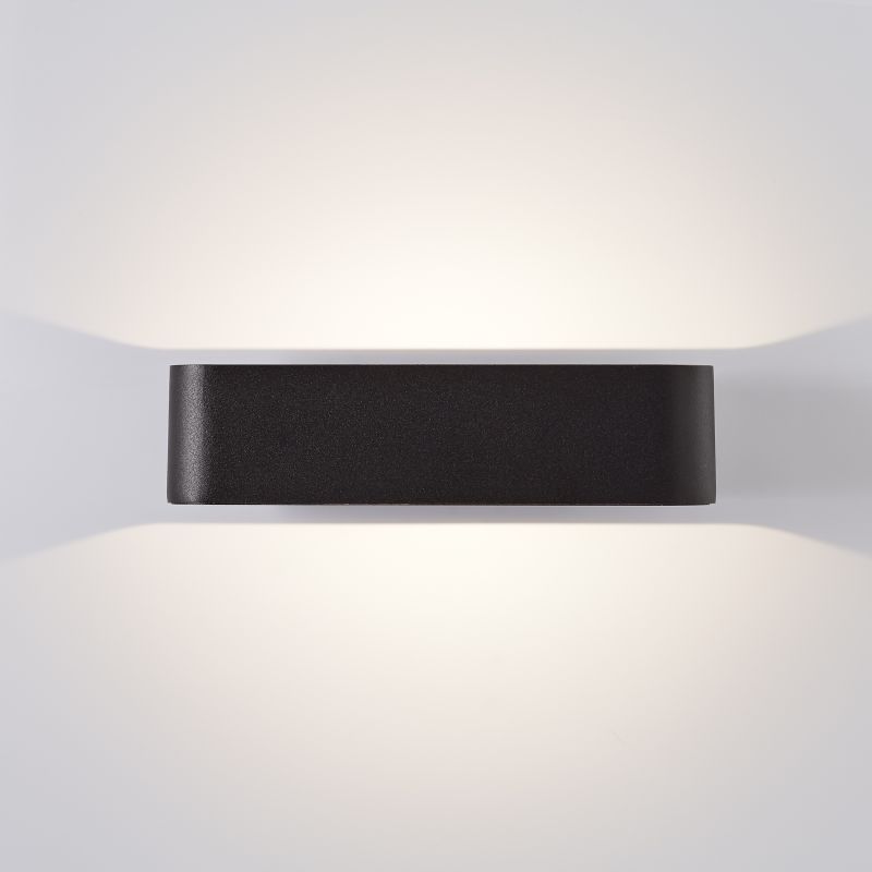 Golda Sort udendørslampe Fra Brilliant - Den fungerer som både praktisk og dekorativ belysning af husfacaden med sit lys, der spreder sig op og ned ad væggen.