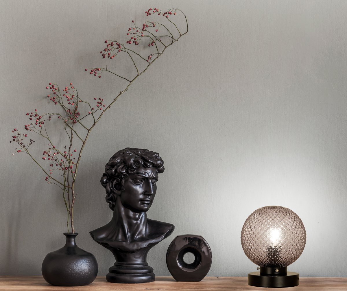 Flory 20cm Røgfarvet bordlampe Fra Aneta Lighting - Det dekorative glas omgiver lyskilden og skaber en varm og harmonisk lysfordeling i rummet.